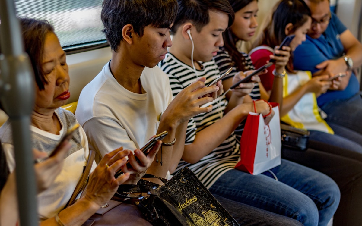Grupo de brasileiros usando o celular para conversar com marcas pelo WhatsApp